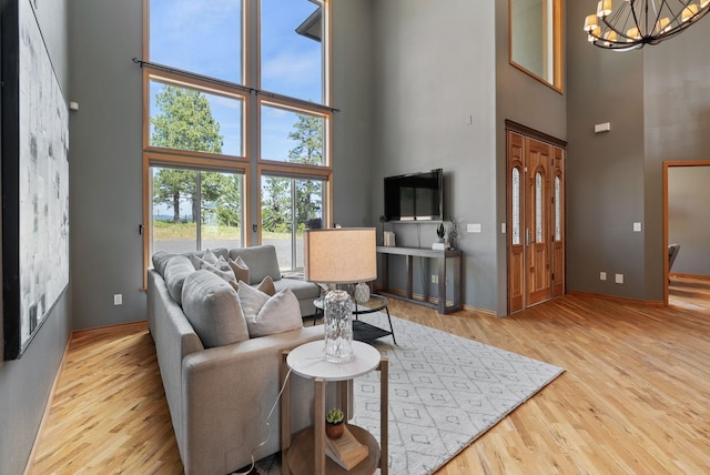 18707 E Terrapin Ln, Otis Orchards, WA 99027 - living area with a towering ceiling, wood finished floors, a chandelier, and baseboards