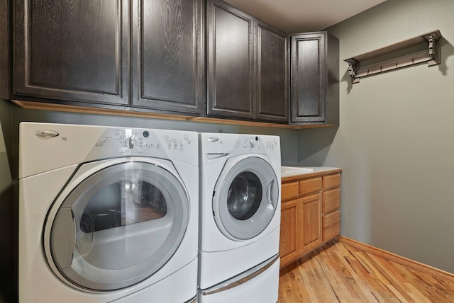 18707 E Terrapin Ln, Otis Orchards, WA 99027 - clothes washing area featuring cabinet space, separate washer and dryer, light wood-type flooring, and baseboards