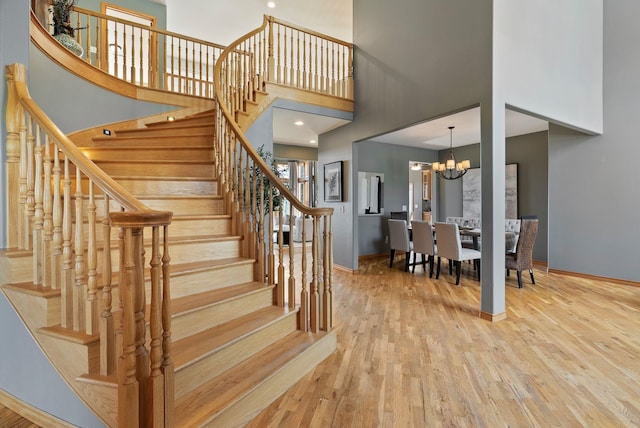 18707 E Terrapin Ln, Otis Orchards, WA 99027 - stairs featuring a chandelier, a high ceiling, baseboards, and wood finished floors