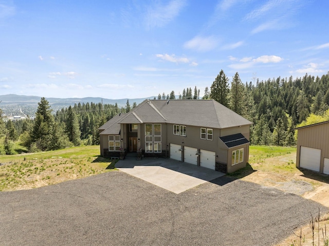 18707 E Terrapin Ln, Otis Orchards, WA 99027 - view of front of home featuring a garage, driveway, a forest view, and a mountain view