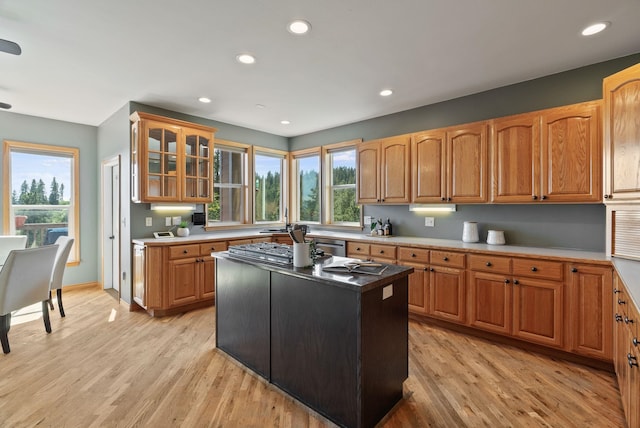 18707 E Terrapin Ln, Otis Orchards, WA 99027 - kitchen featuring light wood-style floors, glass insert cabinets, recessed lighting, a center island, and brown cabinetry