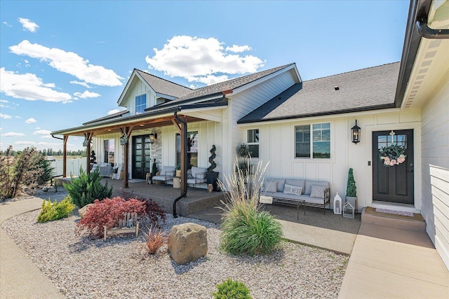 15921 W Four Mound Rd, Nine Mile Falls, WA 99026 - view of front facade with board and batten siding, an outdoor hangout area, a patio area, and roof with shingles