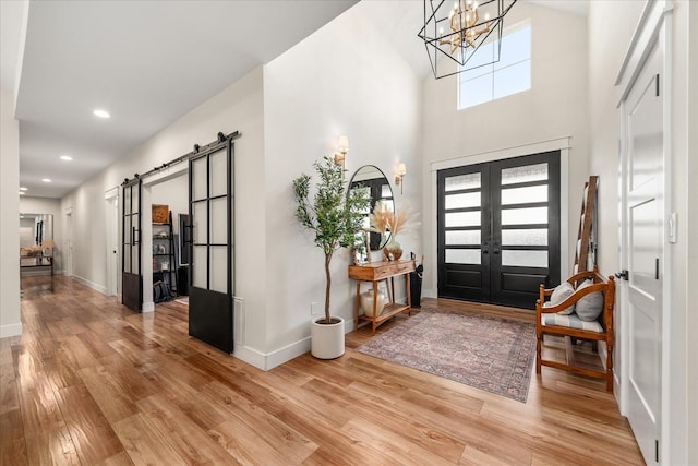 15921 W Four Mound Rd, Nine Mile Falls, WA 99026 - foyer entrance featuring a chandelier, high vaulted ceiling, wood finished floors, french doors, and baseboards