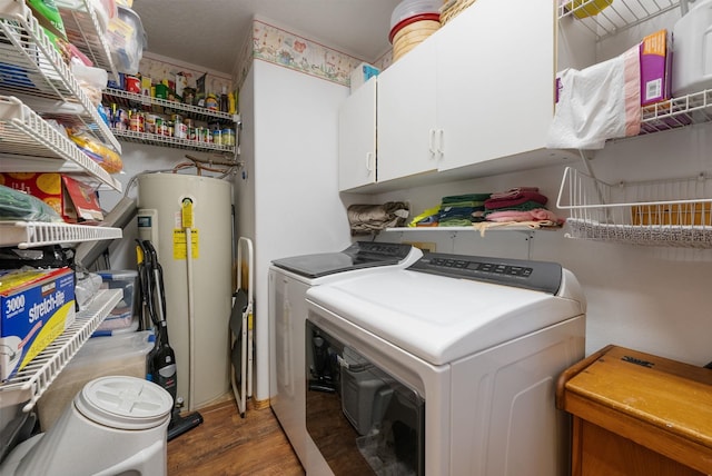 washroom with independent washer and dryer, water heater, wood finished floors, and cabinet space