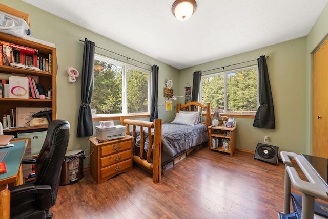 bedroom featuring wood finished floors, a desk, and baseboards