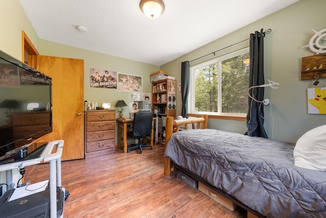 bedroom featuring wood finished floors and a desk
