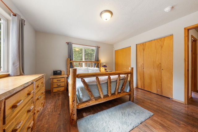 bedroom with dark wood-style flooring and multiple closets