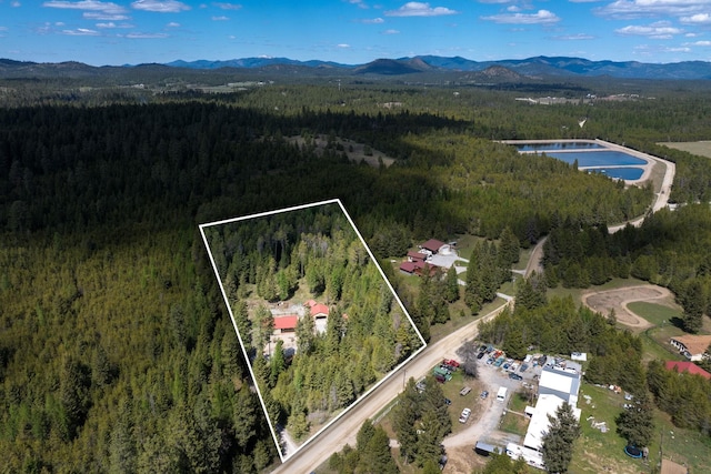 view of property location featuring a forest, a mountainous background, and property parcel outlined