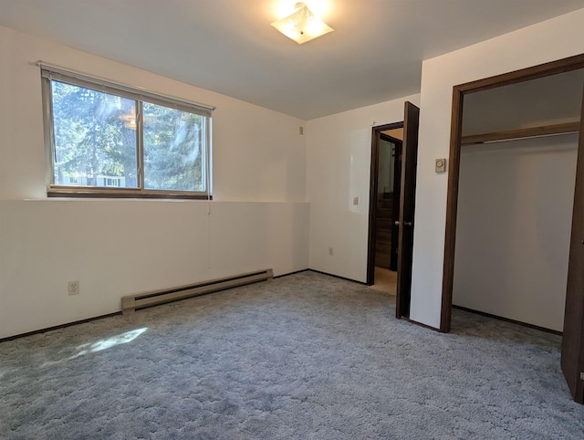 unfurnished bedroom featuring baseboard heating, carpet floors, and a closet