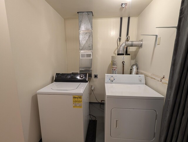 laundry area featuring water heater and washer and clothes dryer