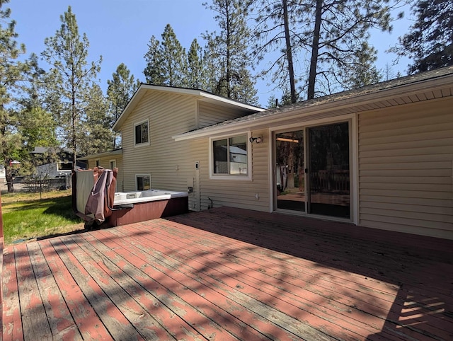 deck featuring a hot tub and fence