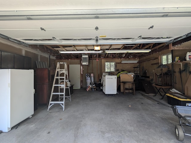 garage with freestanding refrigerator and an AC wall unit