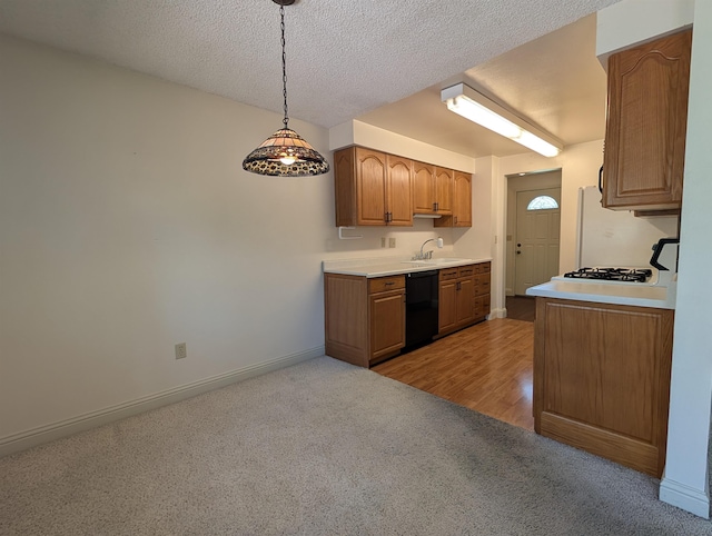 kitchen featuring dishwasher, light carpet, a sink, baseboards, and light countertops