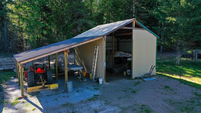 view of pole building with a carport and a wooded view