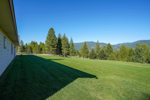 view of green lawn with a mountain view
