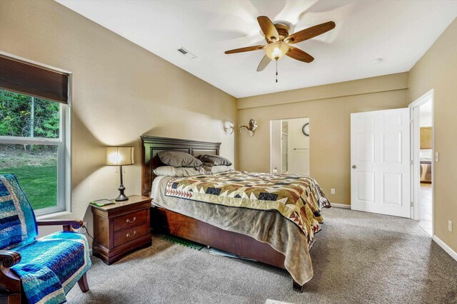 carpeted bedroom featuring a ceiling fan, baseboards, and ensuite bathroom