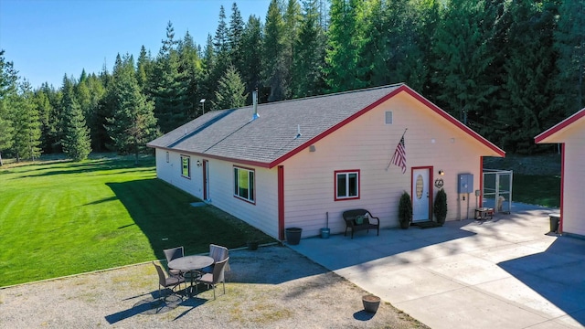 rear view of property with a patio, a yard, a shingled roof, and cooling unit