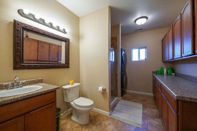 bathroom with stacked washer / drying machine, vanity, toilet, and a shower stall