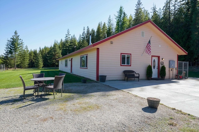 view of property exterior with a yard and a patio