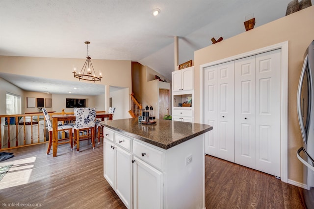kitchen featuring vaulted ceiling, dark wood finished floors, a chandelier, white cabinets, and a center island