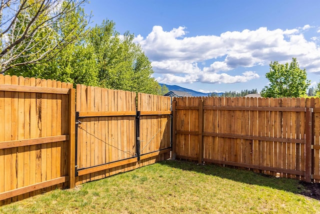 view of yard with a gate and a mountain view