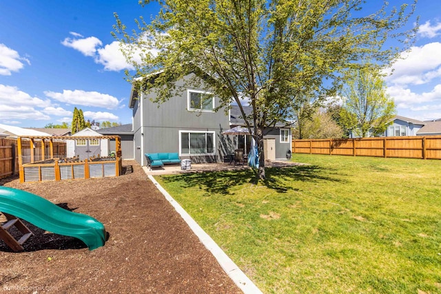 rear view of property featuring a storage unit, an outbuilding, a patio area, an outdoor living space, and a playground