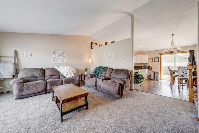 carpeted living area with a chandelier and vaulted ceiling