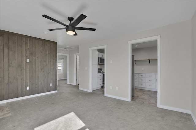 1207 E Garland Ave, Spokane, WA 99207 - unfurnished bedroom featuring a walk in closet, wood walls, light carpet, baseboards, and a closet