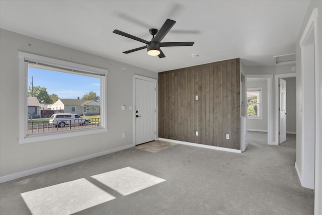 1207 E Garland Ave, Spokane, WA 99207 - unfurnished living room featuring wood walls, carpet, baseboards, and a ceiling fan