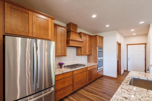 60874 Westview Dr, Nine Mile Falls, WA 99026 - kitchen with appliances with stainless steel finishes, a sink, custom exhaust hood, decorative backsplash, and dark wood-style flooring