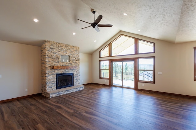 60874 Westview Dr, Nine Mile Falls, WA 99026 - unfurnished living room featuring ceiling fan, dark wood-style floors, baseboards, a stone fireplace, and a textured ceiling