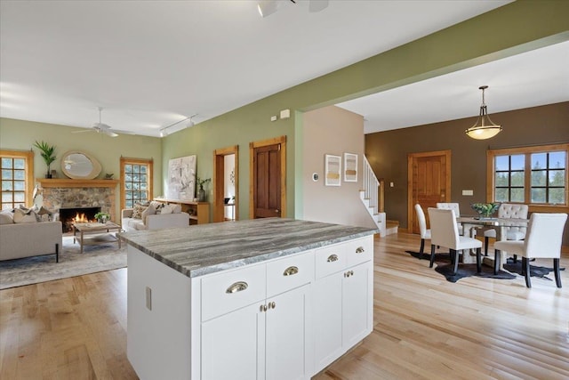 4408 E Spangle Creek Rd, Valleyford, WA 99036 - kitchen with ceiling fan, healthy amount of natural light, light wood finished floors, and a stone fireplace
