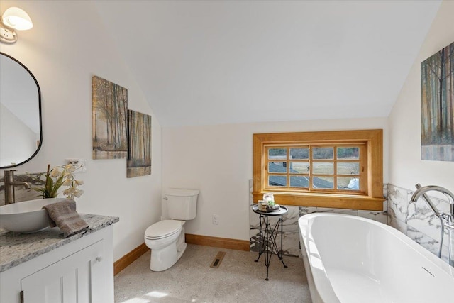 4408 E Spangle Creek Rd, Valleyford, WA 99036 - bathroom featuring lofted ceiling, a freestanding bath, baseboards, vanity, and toilet