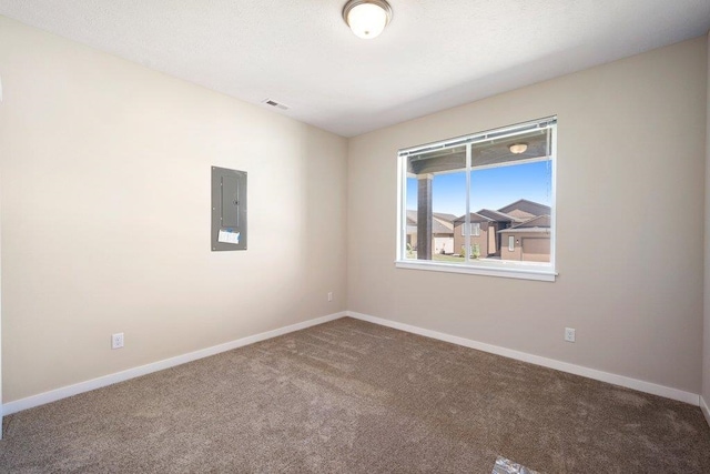 empty room with electric panel, carpet flooring, and baseboards