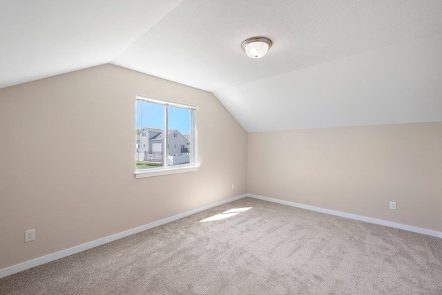 bonus room with carpet floors, vaulted ceiling, and baseboards