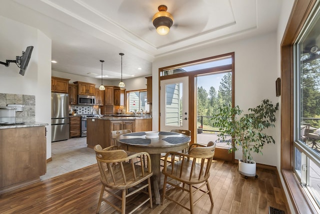 12715 E Deer Creek Rd, Chattaroy, WA 99003 - dining room with healthy amount of natural light, a tray ceiling, light wood-style flooring, and recessed lighting
