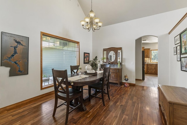 12715 E Deer Creek Rd, Chattaroy, WA 99003 - dining space featuring arched walkways, dark wood-style flooring, a chandelier, high vaulted ceiling, and baseboards