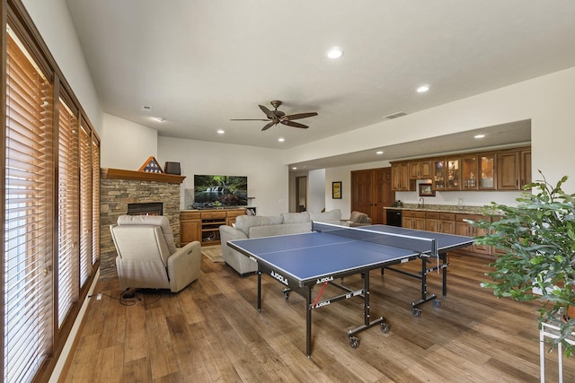 12715 E Deer Creek Rd, Chattaroy, WA 99003 - recreation room featuring wood finished floors, recessed lighting, a ceiling fan, a stone fireplace, and bar