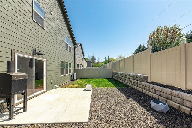 fenced backyard with central AC unit and a patio area