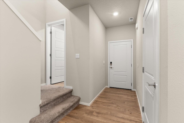 doorway to outside featuring baseboards, wood finished floors, stairway, and recessed lighting