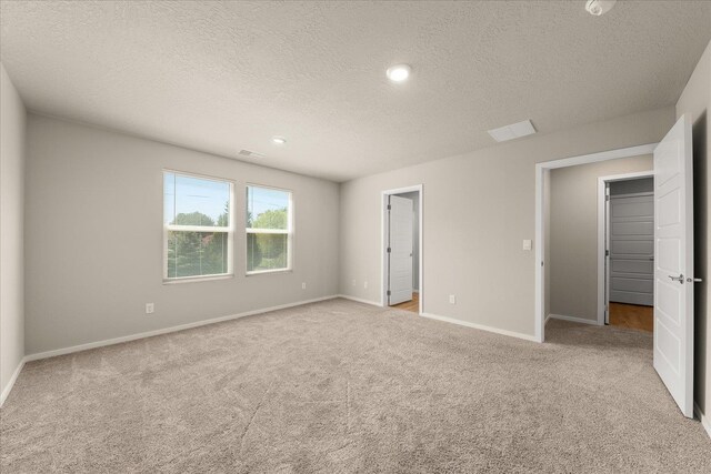 unfurnished bedroom with carpet flooring, a textured ceiling, baseboards, and recessed lighting