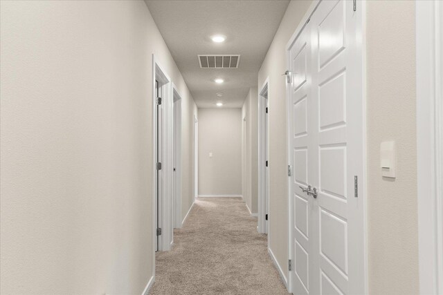 corridor with light colored carpet, baseboards, and recessed lighting