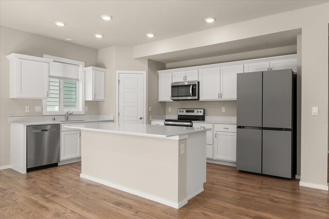 kitchen featuring stainless steel appliances, white cabinetry, dark wood finished floors, and recessed lighting