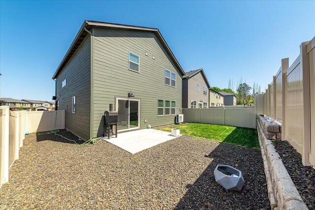 rear view of property featuring a patio and a fenced backyard