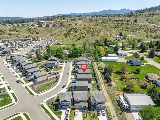 aerial view of property's location featuring nearby suburban area and a mountainous background