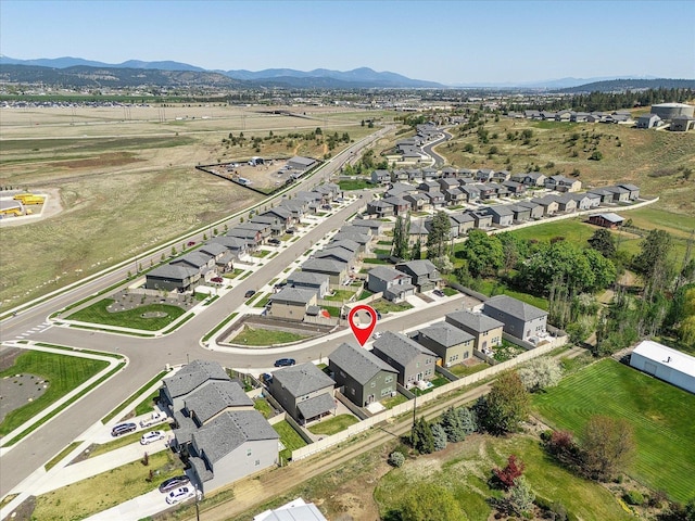 aerial view of property and surrounding area featuring nearby suburban area and a mountain backdrop