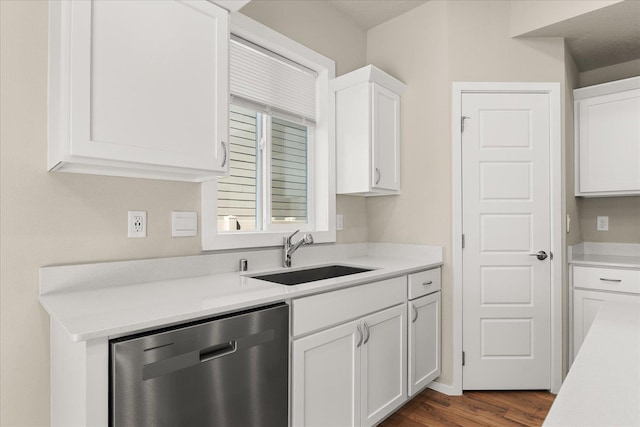 kitchen featuring a sink, stainless steel dishwasher, white cabinetry, and light countertops