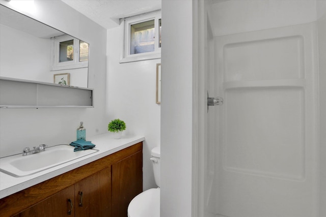 full bath featuring vanity, toilet, and a shower