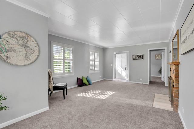 sitting room featuring crown molding, carpet flooring, a brick fireplace, and baseboards