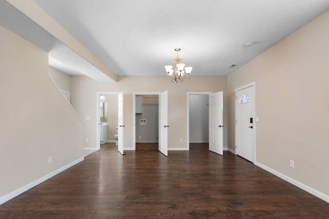 unfurnished dining area with a chandelier, baseboards, and dark wood-style floors